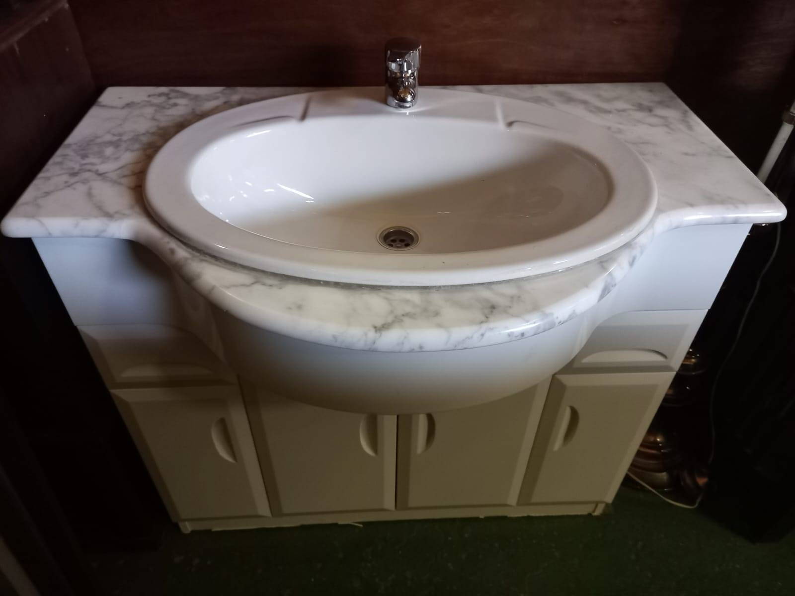 Mueble de baño con encimera de mármol, lavabo y grifo