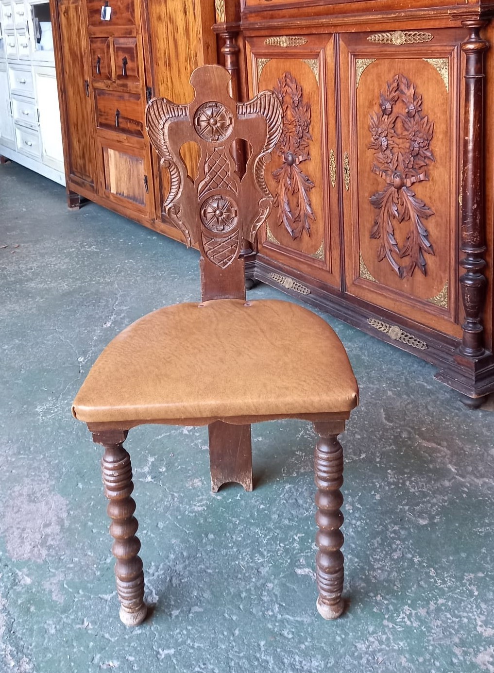 Silla antigua con respaldo ornamentado y patas torneadas